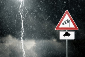Ein Foto von schlechtem Wetter und Blitzen mit einem Schild das vor Sturm und Regen warnt